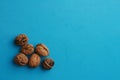 Top view of whole walnuts under the lights on a blue surface