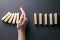 Top view whomen hand stopping falling dominos in a business crisis management conceptual image Royalty Free Stock Photo