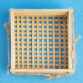 Top view of wicker basket isolated on blue background. Empty handmade wooden bowl. Royalty Free Stock Photo
