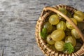 Top view of wicker basket on wooden table full of ripe gooseberries. Royalty Free Stock Photo