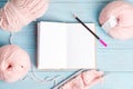 Top view of winding wools and blank notebook for notes and knitting pattern on a light blue wooden background. Royalty Free Stock Photo