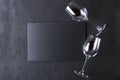 Top view of wineglasses, slate place mat on the black table.Empty space for text