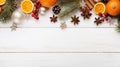 Top view of a winter composition of citrus slices, red berries, Tree branches and spices, on a white wood background. Christmas