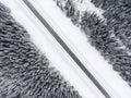 Top view at wintry slippery road passing through the snow covered coniferous forest Royalty Free Stock Photo