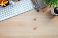 Top view wireless keyboard, coffee cup glasses, notebook and houseplant on wooden table