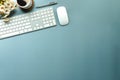 Top view, wireless keyboard, mouse and coffee cup on blue background with copy space