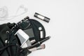 Top view of woman black bag open out with accessories smartphone, perfume, pens, cosmetics, earphone and glasses on white Royalty Free Stock Photo