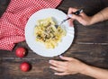 Top View of Woman Eating pasta with Mushrooms on wood table