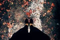 Woman feet in black clothes stand with orange petals fall in raining day