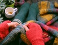 Top view woman sitting at home balcony, knit colorful wool scarf for meaningful handmade winter gift