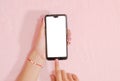 Top view woman hand using blank white screen of mobile smart phone on pink background Royalty Free Stock Photo