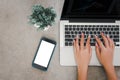 Top view of a woman hand using a laptop computer keyboard and mobile phone mock up a blank screen Royalty Free Stock Photo