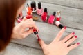 Top view on woman hands, applying red nail polish, with more bot Royalty Free Stock Photo