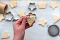 Top view of woman hands cooking a gingerbread cookie in the form of heart, star, cloud and flower. Christmas and New