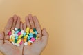 Top view of woman hands holding assorted pharmaceutical medicine pills on yellow background. Hard working and stressful business Royalty Free Stock Photo