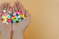 Top view of woman hands holding assorted pharmaceutical medicine pills on yellow background. Hard working and stressful business Royalty Free Stock Photo