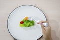 Woman hand eats small portion salad