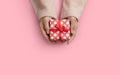 Top view of Woman hands is holding a small red gift box over pink  background Royalty Free Stock Photo