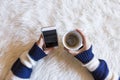 Top view of woman hands holding a smart phone over white background. Cup of coffee besides. Lifestyles.Indoors. Royalty Free Stock Photo