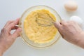 Top view of woman hands holding whisk to beat custard cream on white background Royalty Free Stock Photo