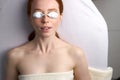 Top view on woman lying on bed before photodynamic face mask therapy