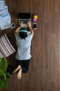 Top view woman lying working on laptop on wooden floor