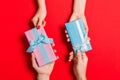 Top view of a woman and a man exchanging gifts on colorful background. Couple give presents to each other. Close up of making Royalty Free Stock Photo