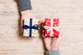 Top view of a woman and a man exchanging gifts on wooden background. Couple give presents to each other. Close up of making Royalty Free Stock Photo