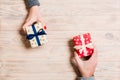 Top view of a woman and a man exchanging gifts on wooden background. Couple give presents to each other. Making surprise for Royalty Free Stock Photo