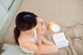 Top view of woman relax on bed with drinking coffee and reading book Royalty Free Stock Photo