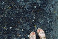 Feet in summer shoes on urban grunge background of asphalt. Conceptual image of legs in boots on city street. Feet shoes