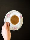 Top View Woman`s Hand Holding Coffee Cup on Table