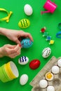 Woman`s hand paints eggs