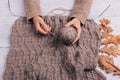 Top view of a woman's hands holding a ball of wool yarn on a tab
