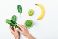 Top view woman's hands holding bunch of spinach near apple Royalty Free Stock Photo