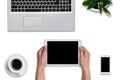 Top view of woman`s hands holding modern tablet with blank screen over white background. Laptop computer, smart phone, tablet, cup Royalty Free Stock Photo