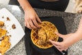 Top view of a woman`s hands plating fried chicken on waffles and syrup