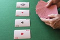 Top view of woman`s hands, with poker cards and aces, on green playing mat