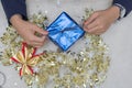 Top view woman s hands wrapping christmas gift, close up, unprepared chistmas presents on cement table at indoors home park