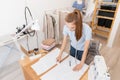 Top view Woman seamstress makes pattern with chalk on fabric for sewing clothes in tailor studio