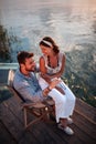 Top view of a woman sitting in a lap of a man by the water, talking, smiling. copy space Royalty Free Stock Photo