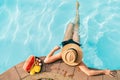 Top view of Woman in straw hat sitting on swimming pool side near plate of tropical fruits- camera Royalty Free Stock Photo