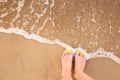 Top view of woman with stylish flip flops on sand near sea. Beach accessories Royalty Free Stock Photo