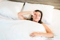 Top view of woman waking up in her bed with white bed linens. healthy sleep and good disposition concept