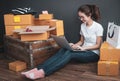 Top view of women working laptop computer from home on wooden floor with postal parcel, Selling online ideas concept -