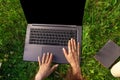 Top view. Woman working on laptop pc computer with blank black empty screen to copy space in park on green grass Royalty Free Stock Photo