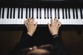 Top view of woman's hands playing piano by reading sheet music. Dark mood. Royalty Free Stock Photo