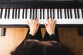 Top view of woman's hands playing piano by reading sheet music. Royalty Free Stock Photo