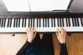 Top view of woman& x27;s hands playing piano by reading sheet music. Royalty Free Stock Photo