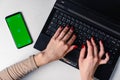 Top view of woman& x27;s hands typing on laptop keypad placed on white office desktop with blank smartphone Royalty Free Stock Photo